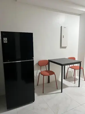 a black refrigerator and a table and two chairs at The Bauhaus near Eastwood in Manila
