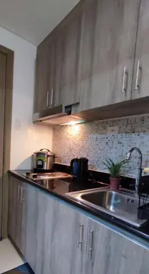 a kitchen with stainless steel cabinets and a sink at Condo Staycation Fame Residences T2 Mandaluyong Philippines in Manila