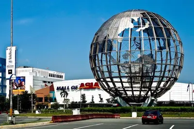 a large metal sphere sitting on the side of a road at The Grand Staycation at MOA - Unit 7102 Hotel-like in Manila