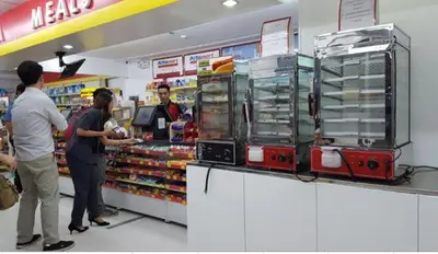 a group of people standing at a store checkout at The Grand Staycation at MOA - Unit 7102 Hotel-like in Manila
