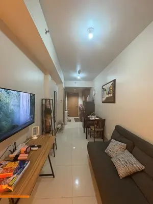 a living room with a couch and a tv at Cozy Haven 2 in Manila