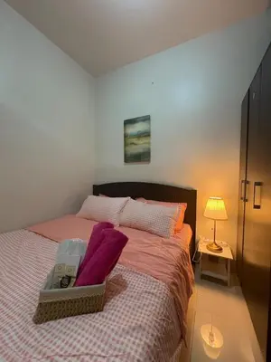 a bedroom with a large bed with purple pillows at Cozy Haven 2 in Manila