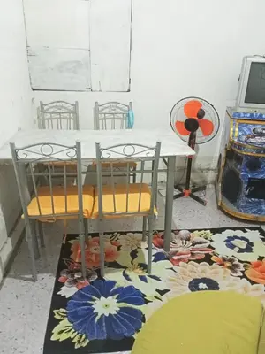 a table and two chairs sitting on a rug at Springbreak Residence in Manila