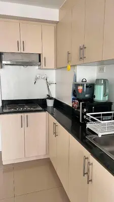 a kitchen with wooden cabinets and a counter top at MNM Place - Sea Residence 1B in Manila