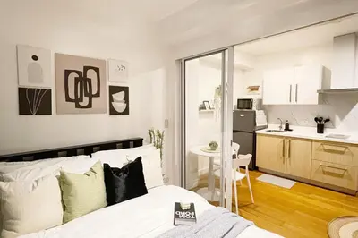 a bedroom with a bed and a small kitchen at The Serene Escape Ph Rockwell Balcony View 1BR in Manila