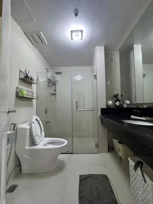 a bathroom with a toilet and a shower and a sink at 2BR Resort Type condo w city view Sheridan in Manila