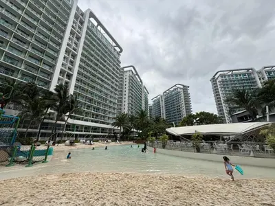 a beach with people in the water and buildings at The Villa at Azure South - Bahamas in Manila