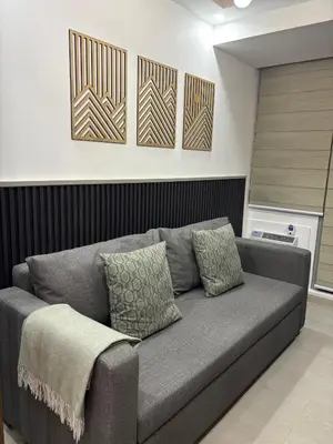 a gray couch in a living room with three pictures on the wall at The Villa at Azure South - Bahamas in Manila