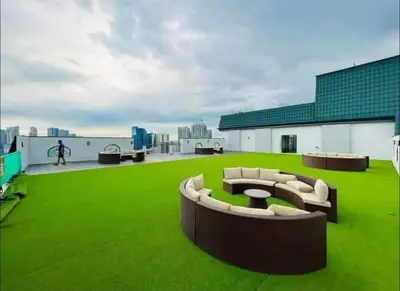 a rooftop with green grass and couches on a building at The Hmlet Manila, Near Poblacion Makati Nightlife in Manila