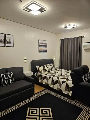 a living room with a bed and a couch at Harmony Suite Hope Trece Cavite in Trece Martires