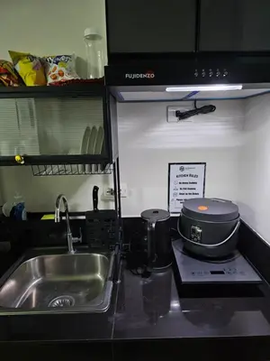 a kitchen counter with a sink and a stove at Harmony Suite Hope Trece Cavite in Trece Martires