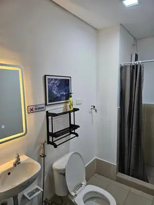 a bathroom with a toilet and a sink at Harmony Suite Hope Trece Cavite in Trece Martires