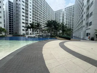 a swimming pool in a city with tall buildings at Beach Haven Condo in MOAs Shore Resort near Okada City of Dreams Solaire in Manila