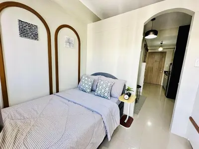 a bedroom with a bed with blue pillows at Peaceful Nest at Shore 2 Res in Manila