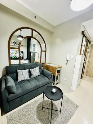 a living room with a couch and a table at Peaceful Nest at Shore 2 Res in Manila