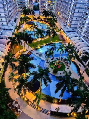 an overhead view of a large pool with palm trees at Shell Residence in Manila