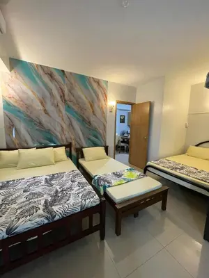 a room with two beds and a painting on the wall at Shell Residence in Manila