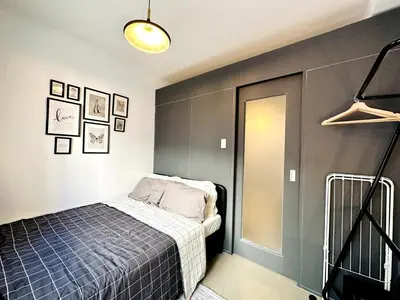 a bedroom with a bed and a wall with pictures at CL10100 House in Manila
