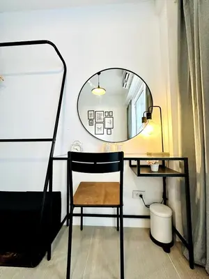a mirror and a chair in a room with a desk at CL10100 House in Manila