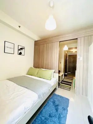 a bedroom with a large bed and a blue rug at CB 1162 House in Manila