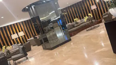 a lobby with couches and a glass elevator in a building at Yuttari in Manila