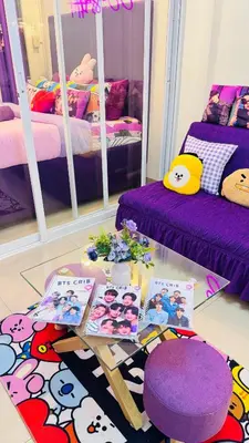 a room with two beds and a table with books at BTS CRIB at MOA PASAY CITY in Manila
