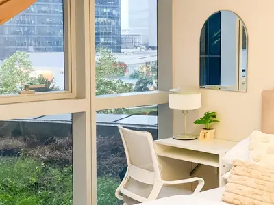 a bedroom with a desk and a chair next to a window at Stylish BGC Condo by Grand Hyatt #upt16k in Manila
