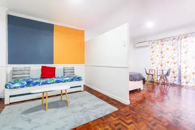a living room with a bed and a colorful wall at Stylish Hip studio in the Heart of Poblacion, in Manila