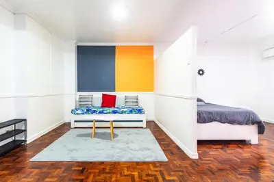 a bedroom with a bed and a bench in a room at Stylish Hip studio in the Heart of Poblacion, in Manila