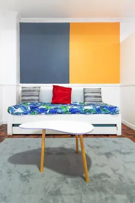 a couch in a room with a colorful wall at Stylish Hip studio in the Heart of Poblacion, in Manila