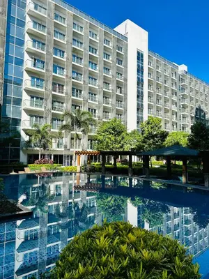 a large building with a pool in front of it at 81 Newport Blvd Cluster 5 Unit 3F by Rechelle Nunag in Manila