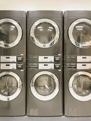 four washing machines are lined up in a row at JFam Suites Allegra Condo with Balcony, FREE Parking in Manila