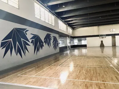 an empty basketball court with black leaves painted on the wall at JFam Suites Allegra Condo with Balcony, FREE Parking in Manila