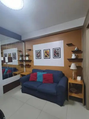 a living room with a blue couch in a room at Shore residences tower D by Ben in Manila
