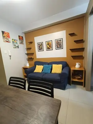 a living room with a blue couch and a table at Shore residences tower D by Ben in Manila