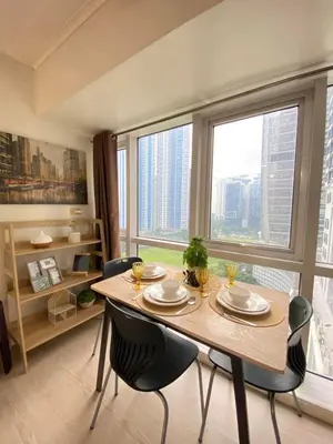 a dining room with a table and chairs and a large window at South of Market Private Residences nr SM Aura BGC in Manila