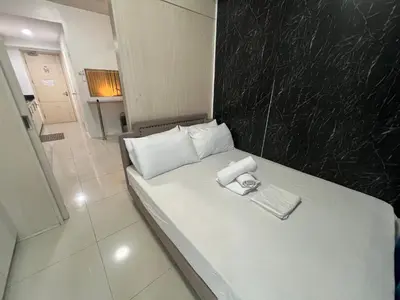 a small white bed in a small room at Sea Residences MoaPasay City By Jerson in Manila