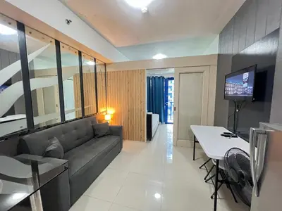 a living room with a couch and a table at Sea Residences MoaPasay City By Jerson in Manila
