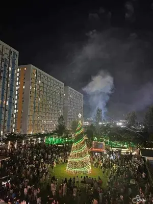 a large crowd of people standing around a christmas tree at 1 BR Nordic Suite with Netflix, Disney, Prime in Manila