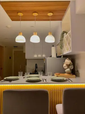 a kitchen with a counter with plates and lights at The Cozy Cove - 3BR with Netflix, Prime and KTV in Manila