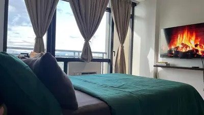 a bedroom with a bed with a fire in the window at Max 1 Small Pet Allowed! Choose Pet Rate Plan if you have a pet with you! Gramercy Residences at 42nd Floor with Pool and Gym Access in Manila