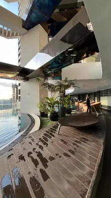 a person walking in a building with a pool at Max 1 Small Pet Allowed! Choose Pet Rate Plan if you have a pet with you! Gramercy Residences at 42nd Floor with Pool and Gym Access in Manila
