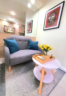 a living room with a couch and a table at Lovely, Cozy One Bedroom with Wi-fi Pool in Pasig in Manila