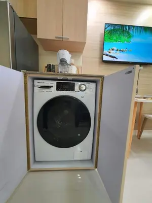 a washing machine in a kitchen with a tv at Lovely, Cozy One Bedroom with Wi-fi Pool in Pasig in Manila