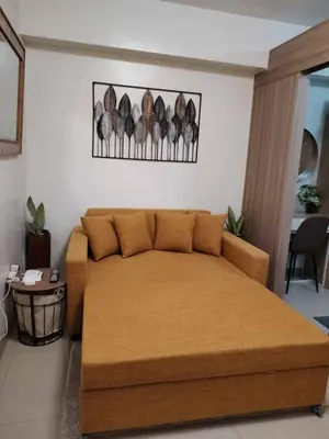 a bedroom with a large bed and a table at Qween E Choice 2 Qween bed Condo in Manila
