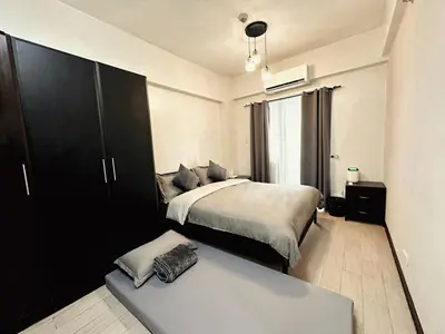 a bedroom with a bed and a bench in it at Hestia Homes near Airport in Manila