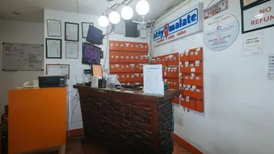 a shop with a brick counter and signs on the wall at Stay Malate Hostel by RedDoorz in Manila