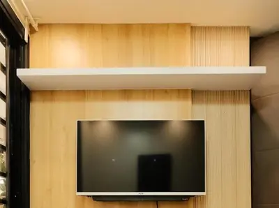 a flat screen tv on a wall with a shelf at Cozy Crib2 in Manila