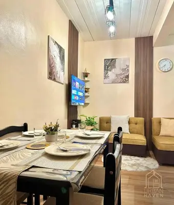 a dining room with a table and a couch at Staycation in Alabang in Manila