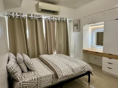 a bedroom with a bed with a shower curtain at Kathys Crib 2Bedroom MOA View at Shell Residence in Manila